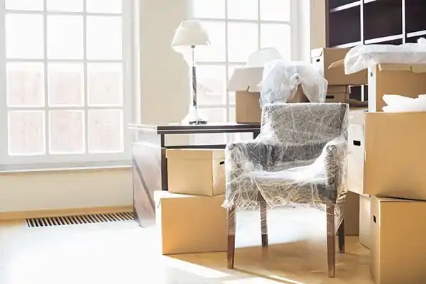 Inplastade möbler vid flyttstädning i Stockholm
